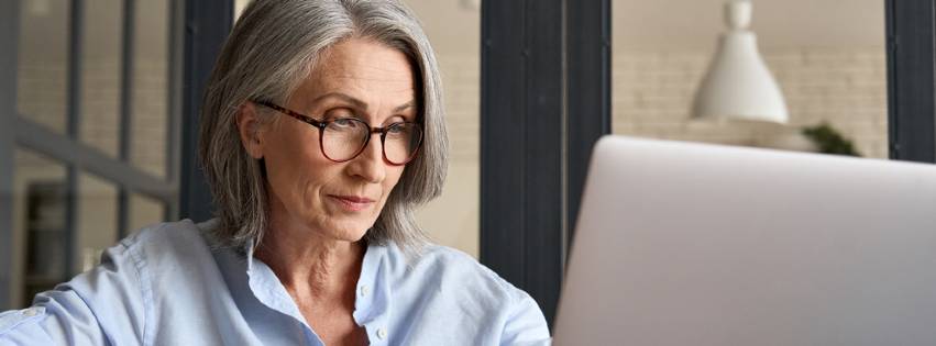 a senior woman uses a laptop for lifelong learning