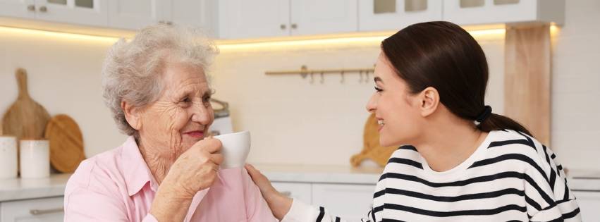 a senior woman enjoys a conversation with a staff member