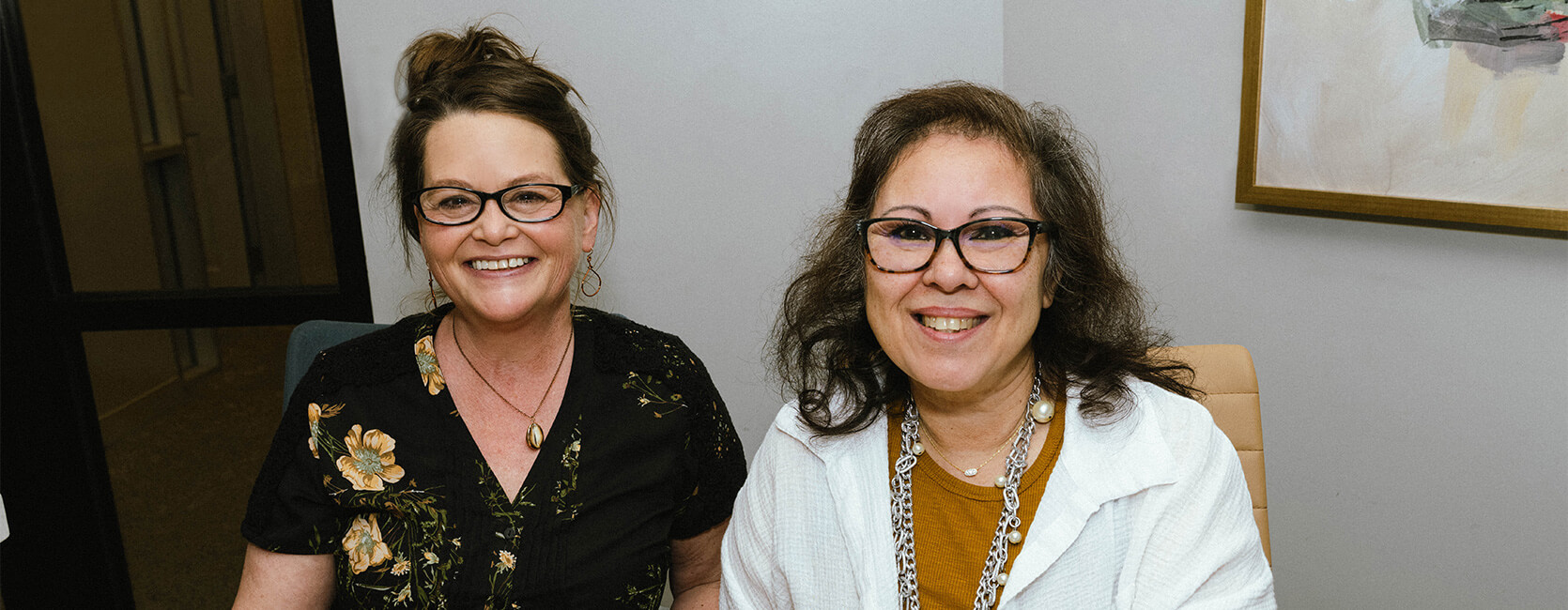 Two women smiling at a senior living community gathering.