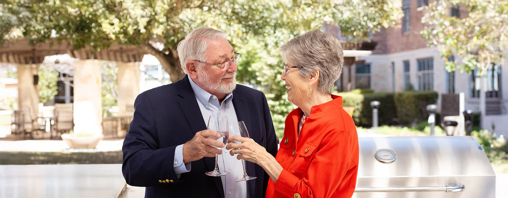 Elderly couple toasting with wine glasses outdoors in a community setting