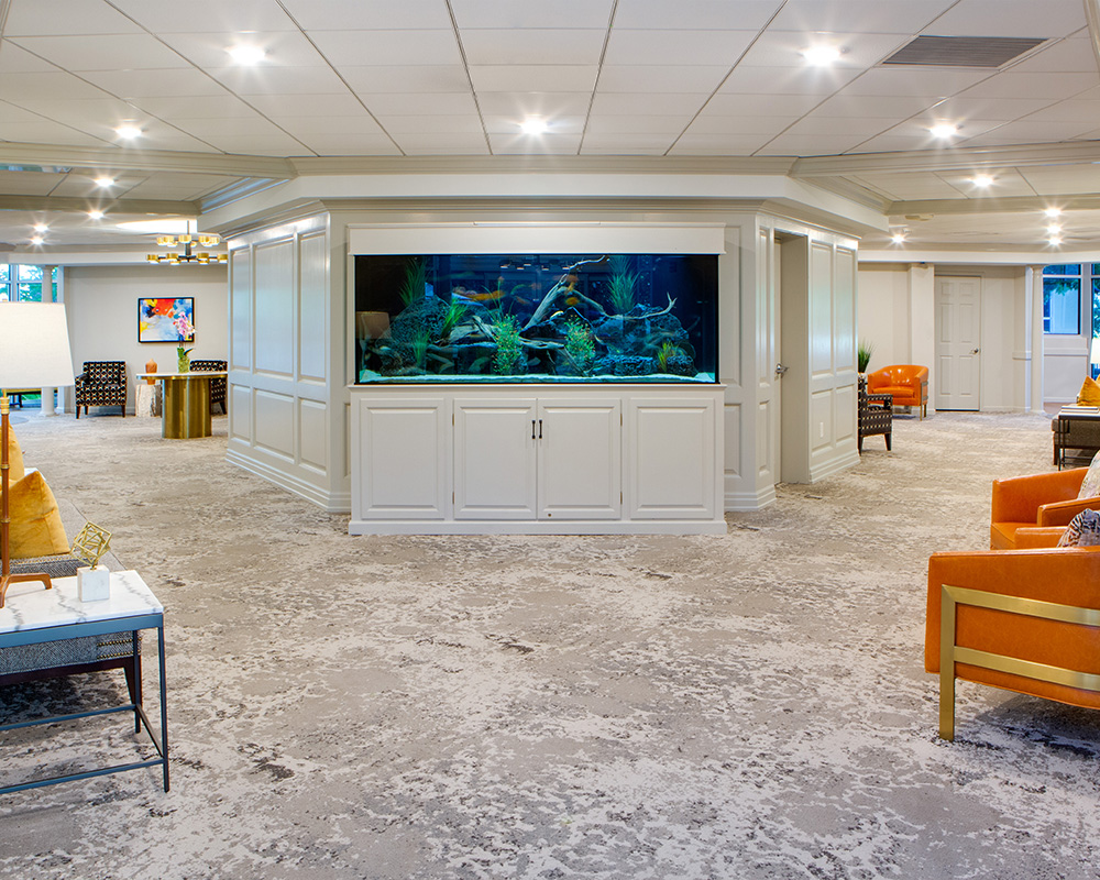 Spacious lobby with a large aquarium and modern seating in a community building.