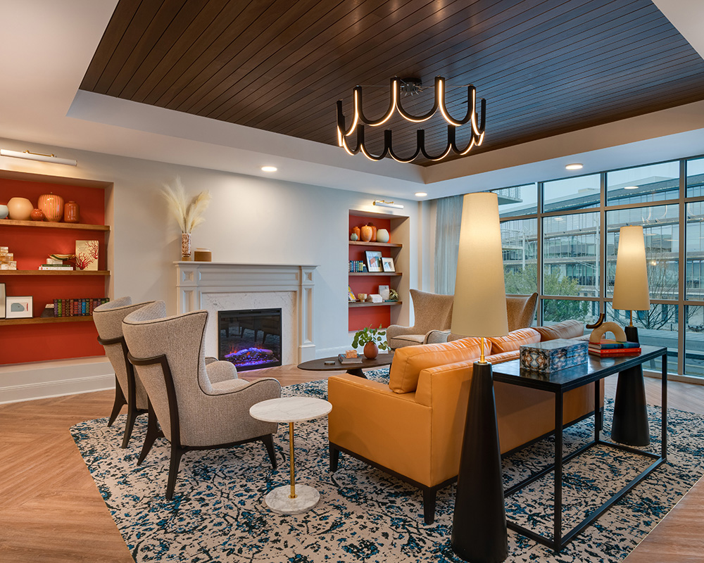 Stylish lounge area with modern furniture and large windows in senior living community.