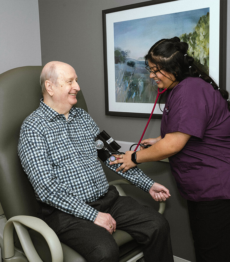 A nurse checks an elderly mans blood pressure in a senior community unit.