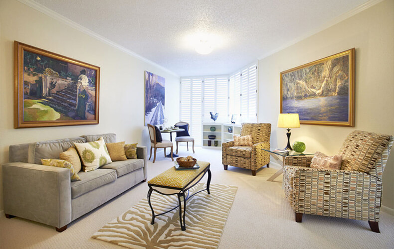 Bright living room with modern furnishings and large wall artworks.