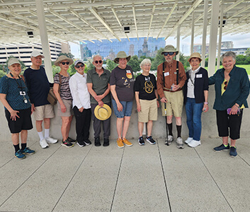 Group of seniors enjoying a sunny outdoor activity wearing casual clothes and hats.