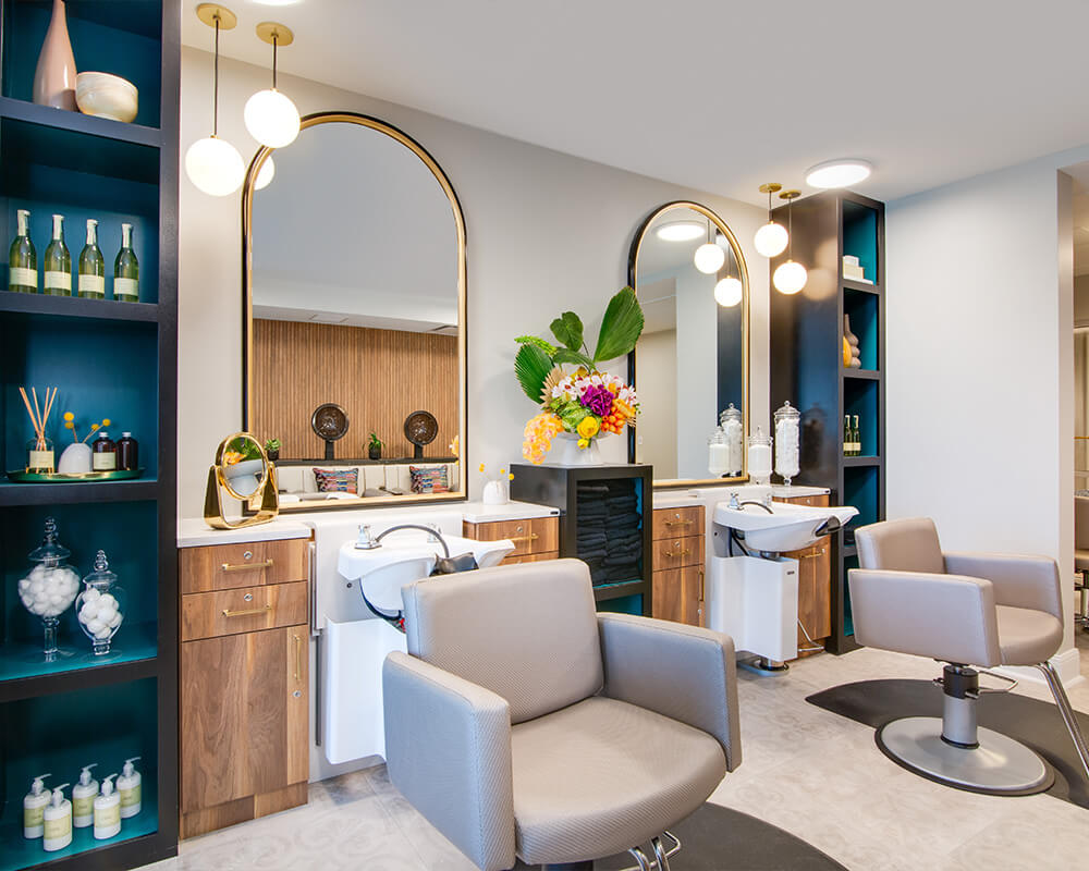 Modern salon area in a senior living community with chairs and mirrors.