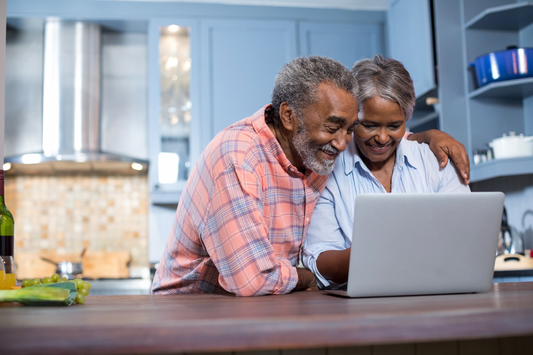 Happy senior couple smiling at laptop screen