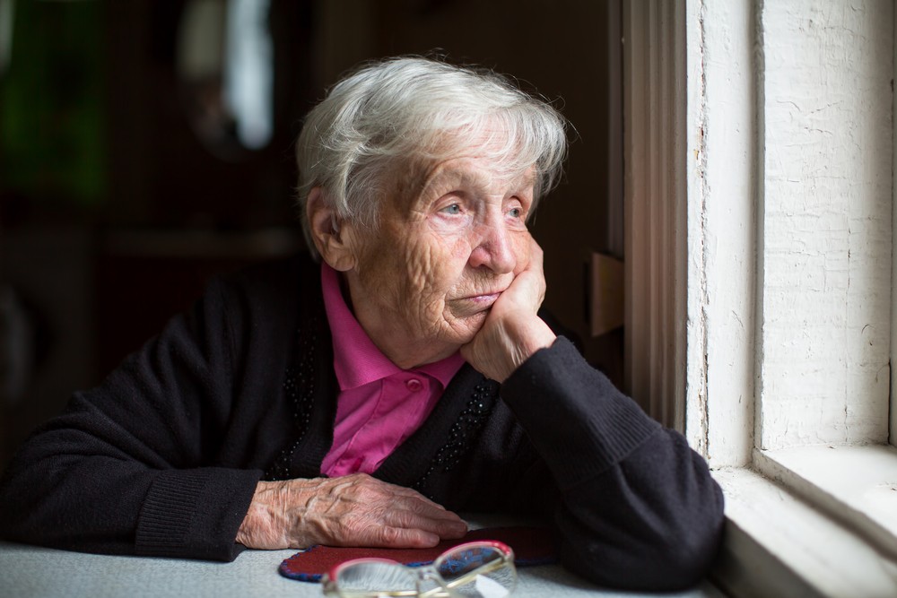 Senior woman with seasonal affective disorder looking out window