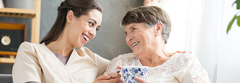 Nurse laughing with senior living resident